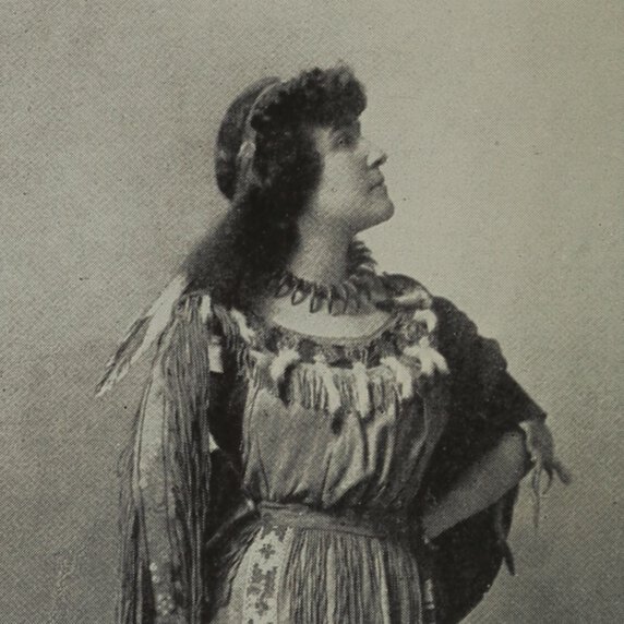 E. Pauline Johnson, standing in half profile with head turned to her left.
