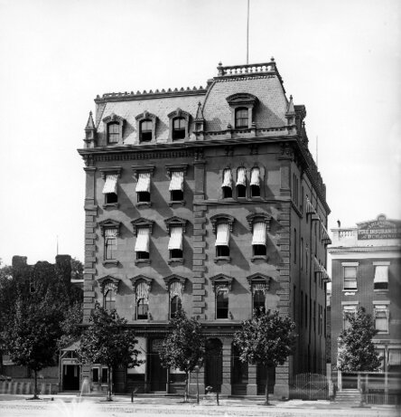 Five-story stone building with trees in front.
