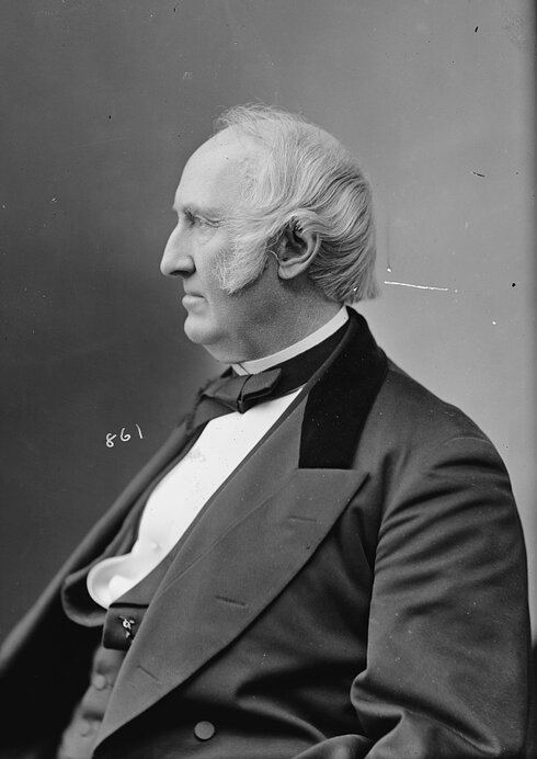 Portrait of a seated man in a suit.