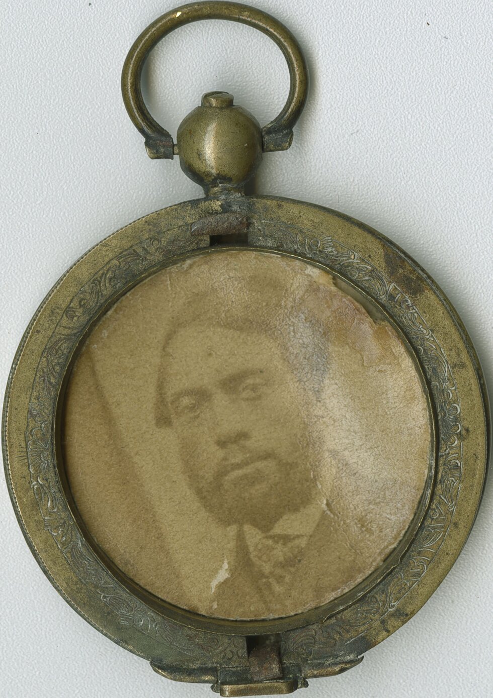 Portrait of a man inside of a large circular locket.