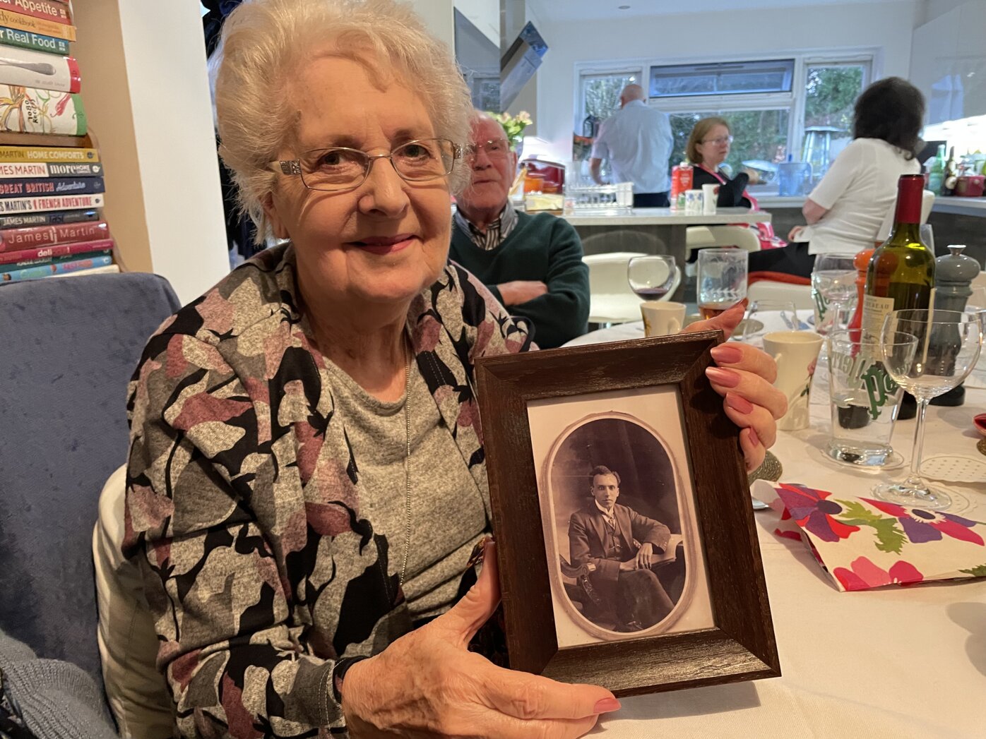 Betty Trussler holding a framed photo of her grandfather, William A. Craft.