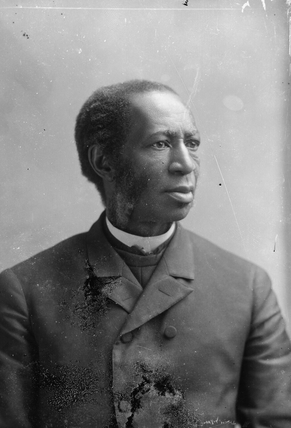 Portrait of a man in a suit looking away from the camera.
