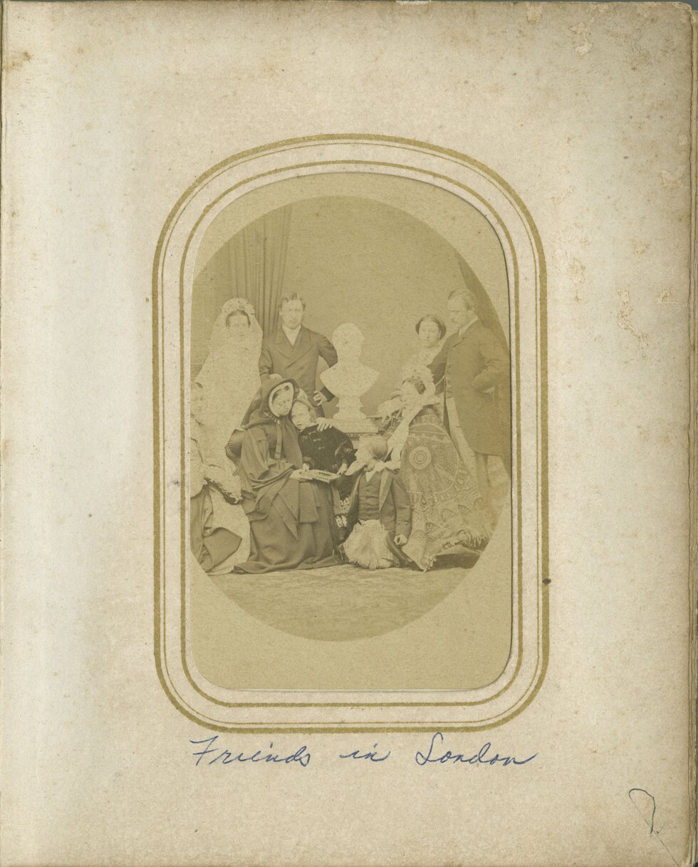 Portrait of a group of people, some seated some standing, in a photography studio.