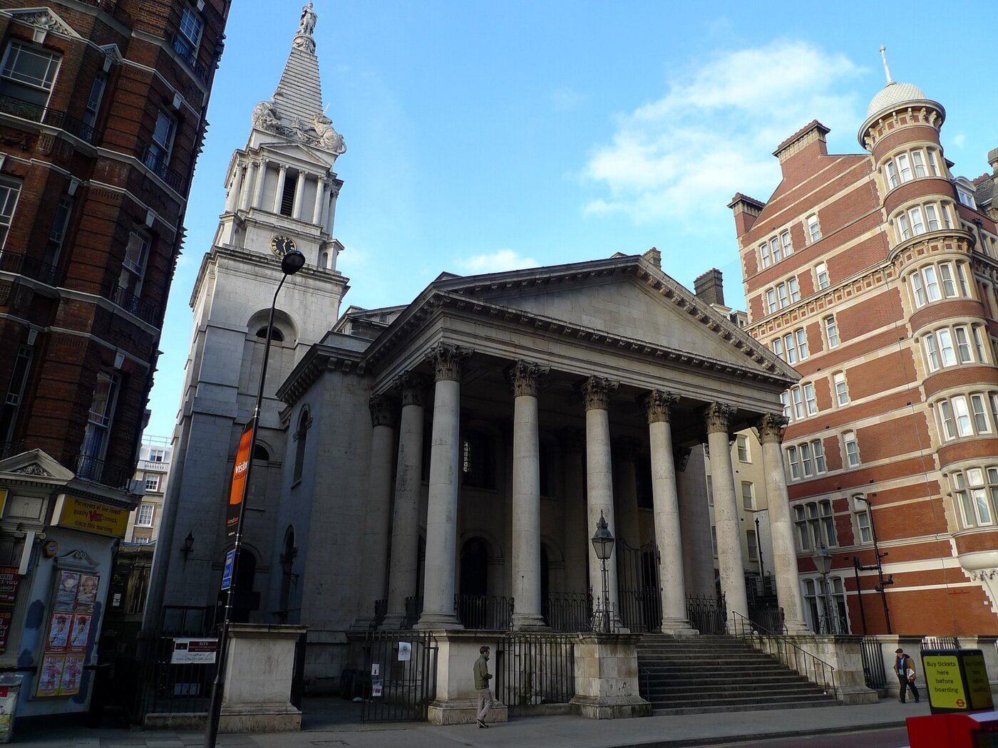A large stone church with columns and a steeple in the background.
