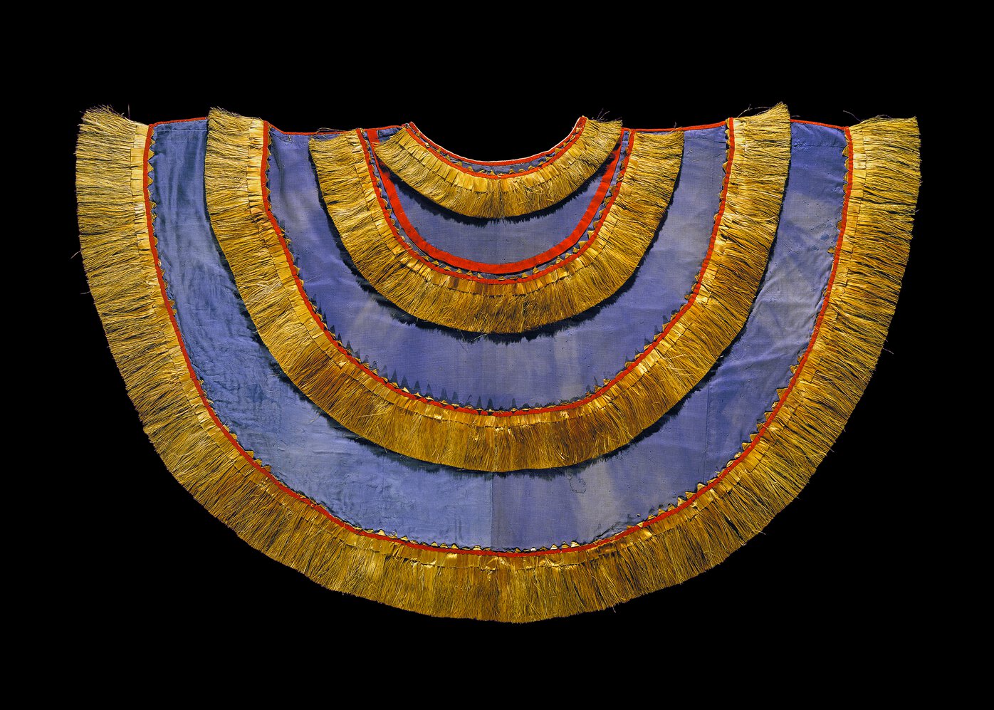 Cloak in half-cricle shape facing down, with blue cloth body and gold fibre rows trimmed with red.