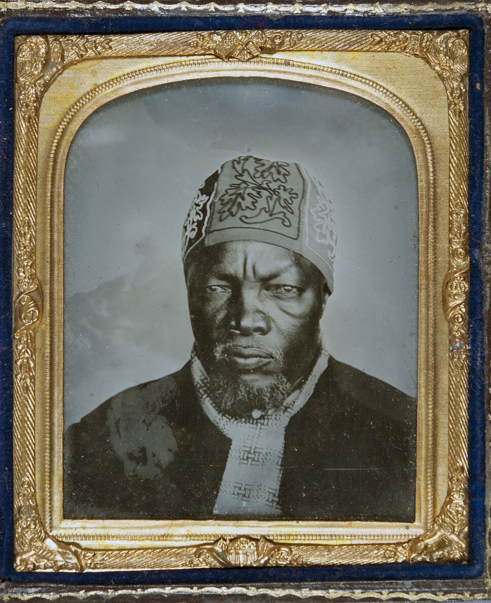 Head and shoulders portrait of Sechele I, in a golden frame.