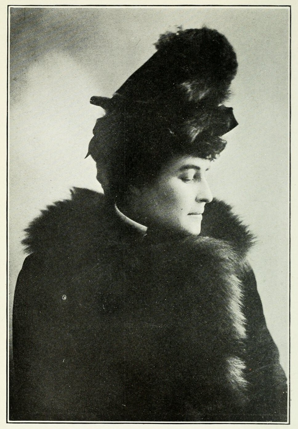 Head and shoulders portrait of E. Pauline Johnson, facing left. Johnson wears a hat and fur coat.