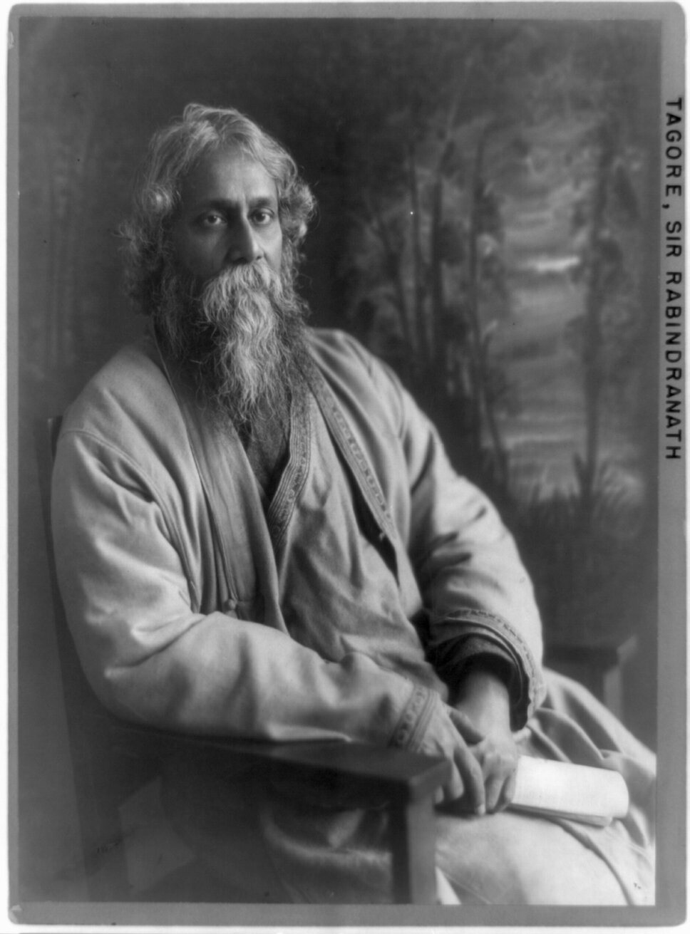 Rabindranath Tagore in three-quarter-length portrait, seated, facing to his right.