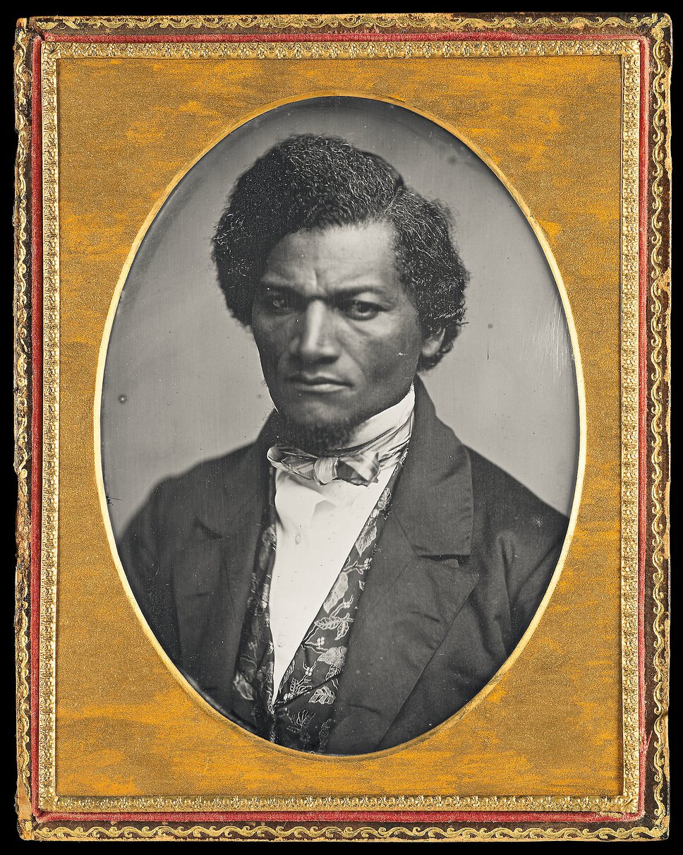 Head and shoulder portrait of Frederick Douglass in a gold frame.