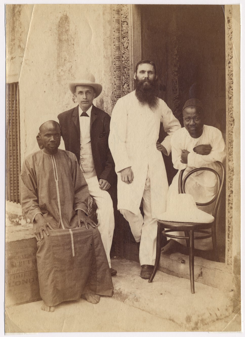 Abdullah Susi, Henry Charles Goodyear, [?] Gill, and Feragi posed near decorated doorway.