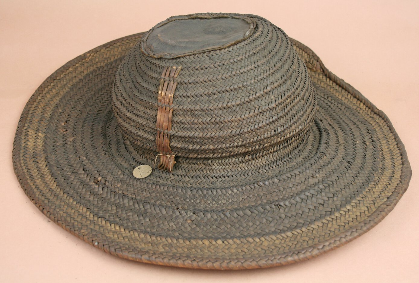 Brown-gray hat with beige rim made of vegetal fibre and leather.