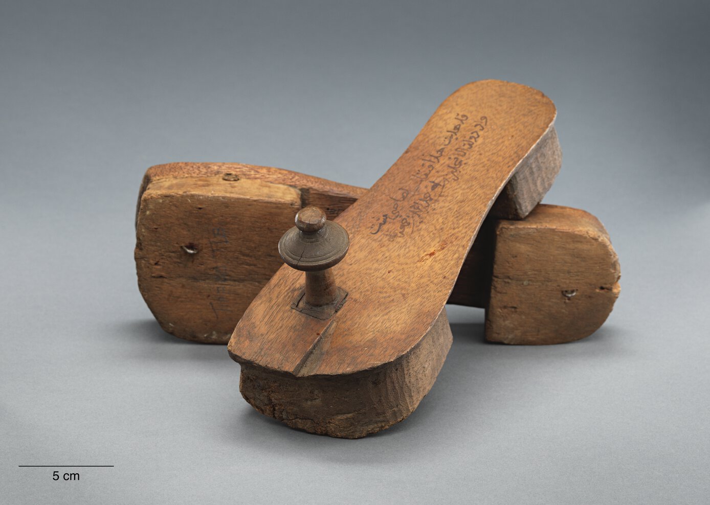 Tippu Tip's inscribed clogs, one placed on its side, the other with its heel on the first.