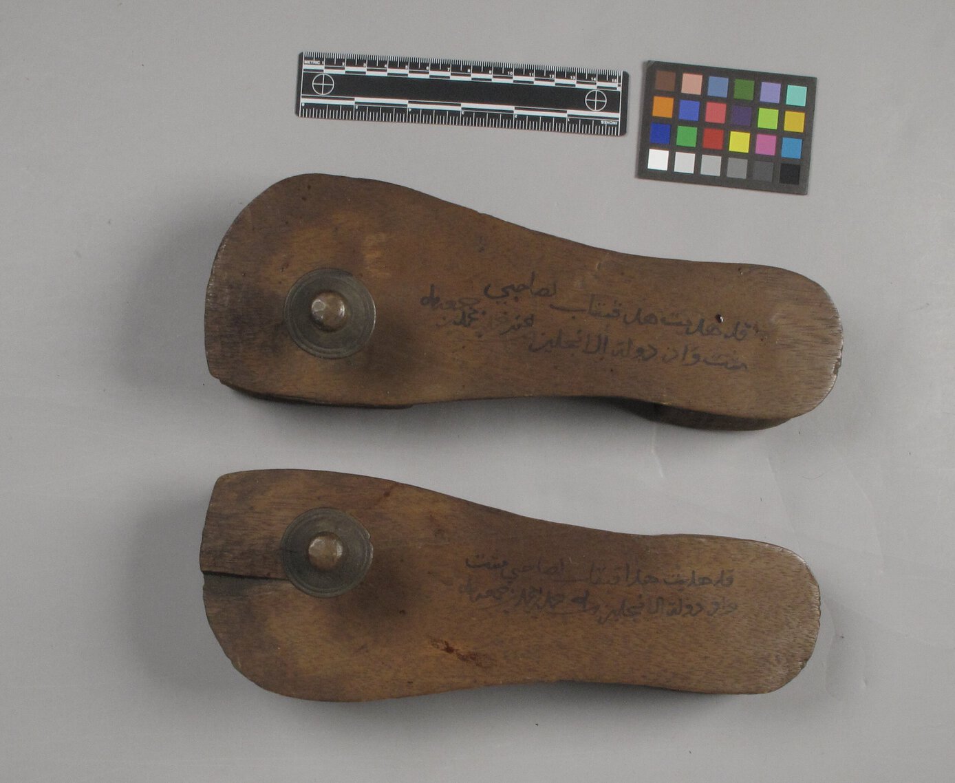 Tippu Tip's inscribed clogs side by side, as viewed from the top with Arabic inscriptions showing.