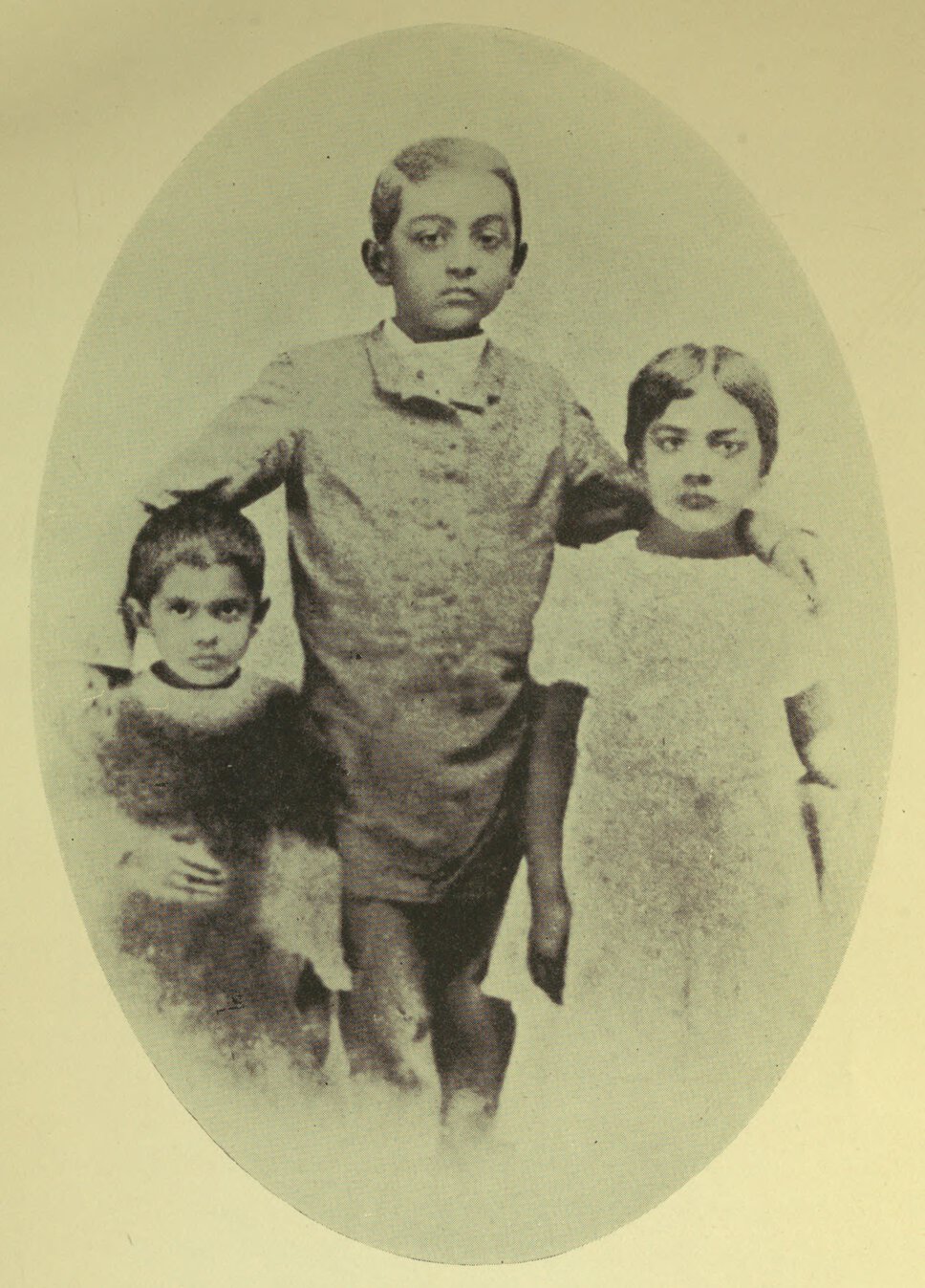 Toru, Abju, and Aru Dutt standing, facing forward, with arms around one another.