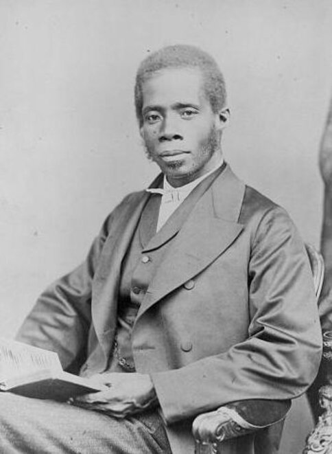 Edward Wilmot Blyden, seated, holding book, turned to his right, but facing forward.