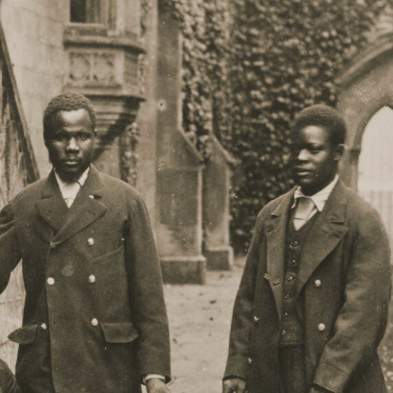 Abdullah Susi and James Chuma in front of some gothic architecture.