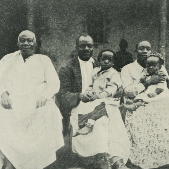 Ham Mukasa’s father, Ham Mukasa with a child, and Ham Mukasa’s wife with a child, all seated.