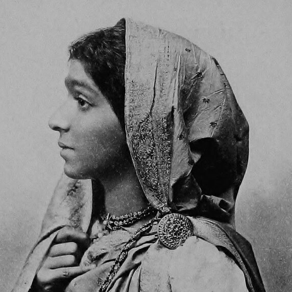 Head and shoulders portrait of Sarojini Naidu, in half profile facing to her right.