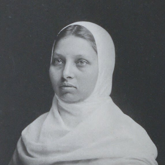 Head and shoulders portrait of Pandita Ramabai Sarasvati, facing to her right, with head covered.