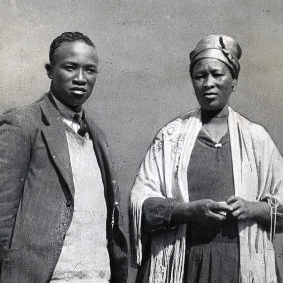 Portrait of Tshekedi Khama in three-quarters profile, and Semane Khama facing forward, standing.