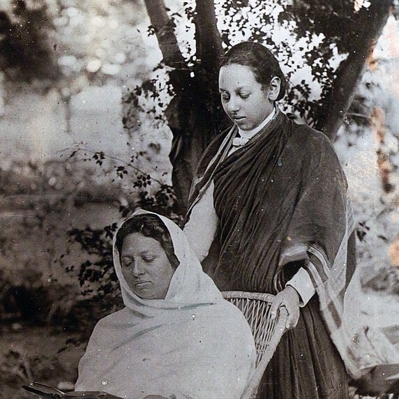 Pandita Ramabai Sarasvati, seated, with Monramabai standing, looking over Sarasvati's shoulder.