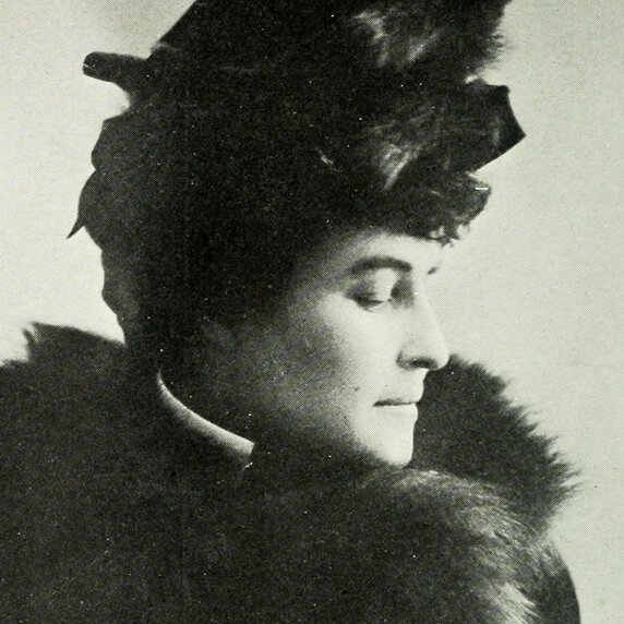 Head and shoulders portrait of E. Pauline Johnson, facing to her left, with hat and fur coat.