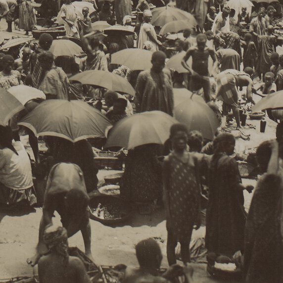 African market full of people with many holding umbrellas.