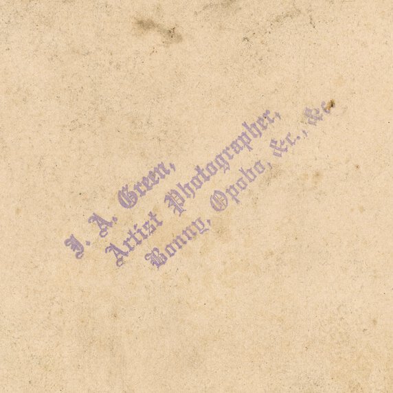 Stained paper with purple stamp that says, “J.A. Green, Artist Photographer, Bonny Opobo, &c, &c