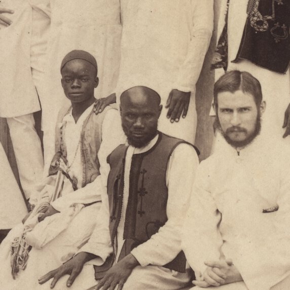 Abdullah Susi, seated and forward, between a younger boy (left) and an adult male (right).
