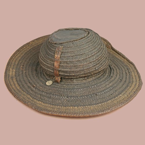 Brown-gray hat with beige rim made of vegetal fibre and leather.