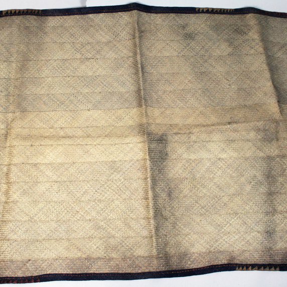 Large plaited palm leaf travelling mat, plain except for decorative boarder strip.