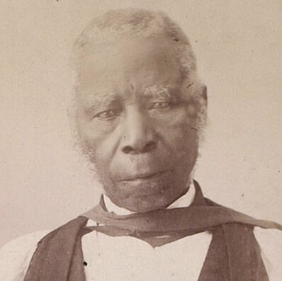 Samuel Ajayi Crowther in formal church attire, standing, facing forward, with right hand on a book.