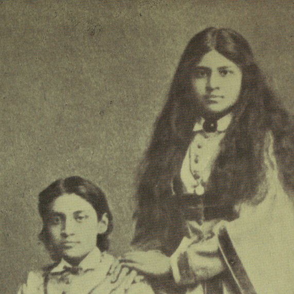 Aru Dutt seated, facing forward with Toru Dutt standing at her side, hands folded on Aru's shoulder.